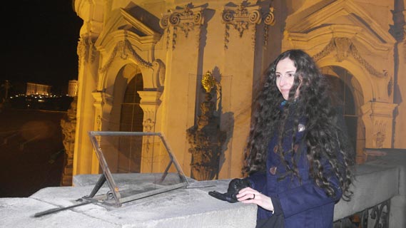 Radka on top of a tower in Prague, with messy hair in the wind